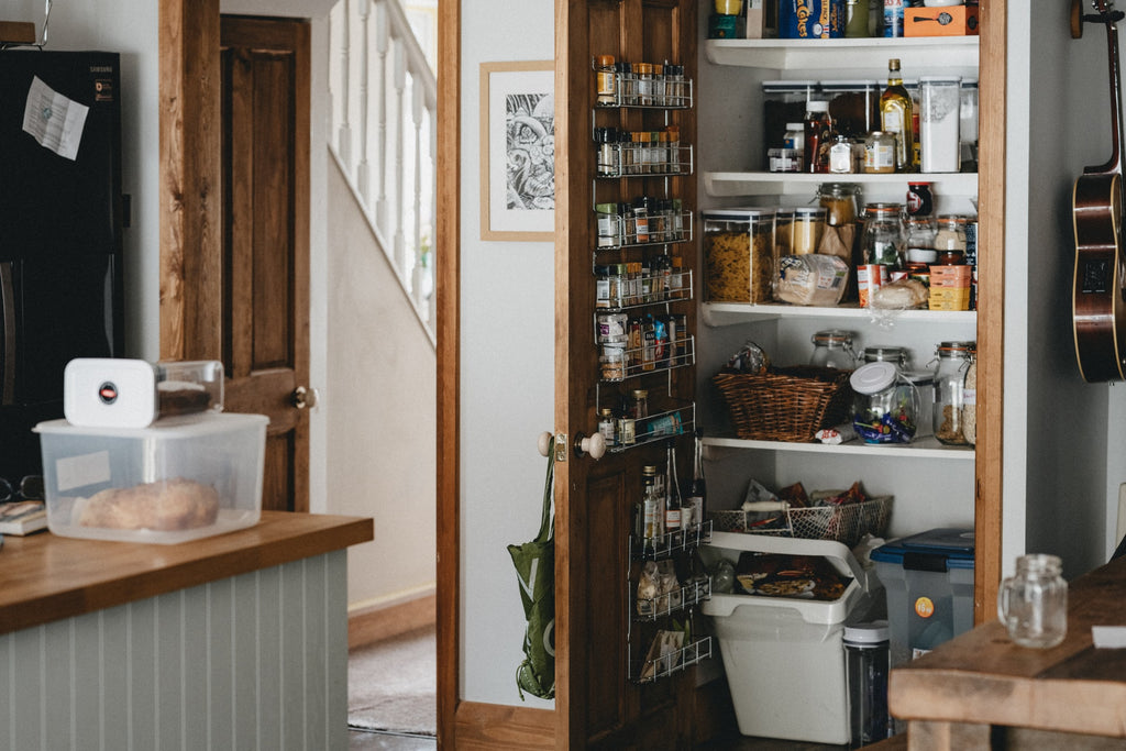 Country Pantry door open full of dry goods, spices and condiments.